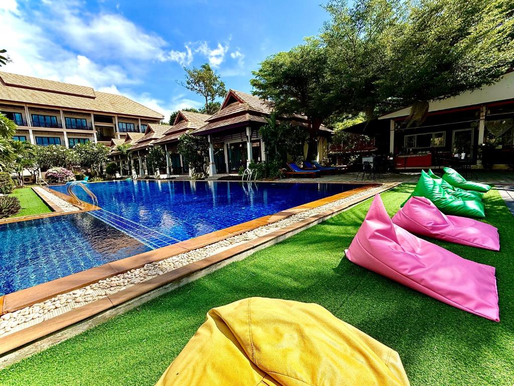 a swimming pool with colorful inflatables on the grass at Poolsawat Villa - SHA Plus in Lamai