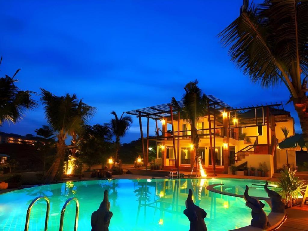 un grupo de personas en una piscina por la noche en Phu View Resort Khao Yai, en Mu Si