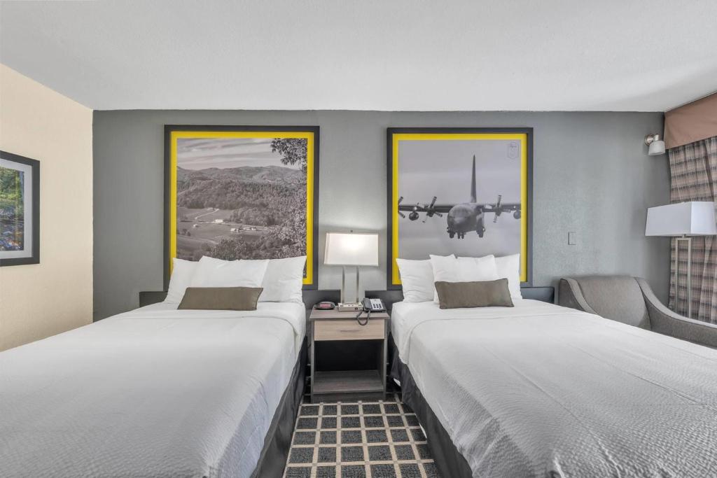 a hotel room with two beds and a plane on the wall at Super 8 by Wyndham Morganton in Morganton