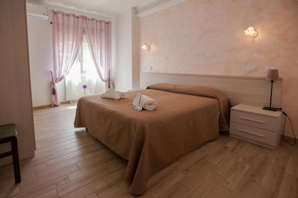 ein Schlafzimmer mit einem Bett mit zwei Handtüchern darauf in der Unterkunft Carillon in Civitavecchia