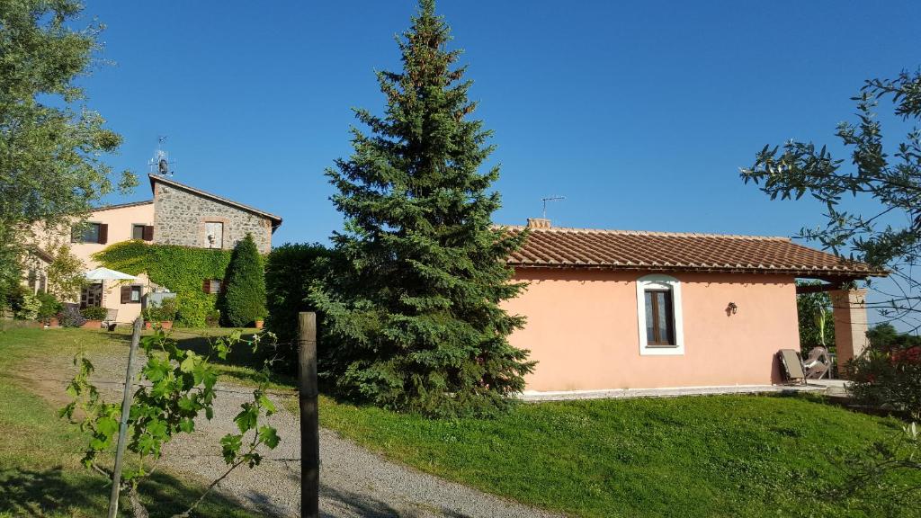 una casa con un árbol delante de ella en Casale Citerno, en Bolsena