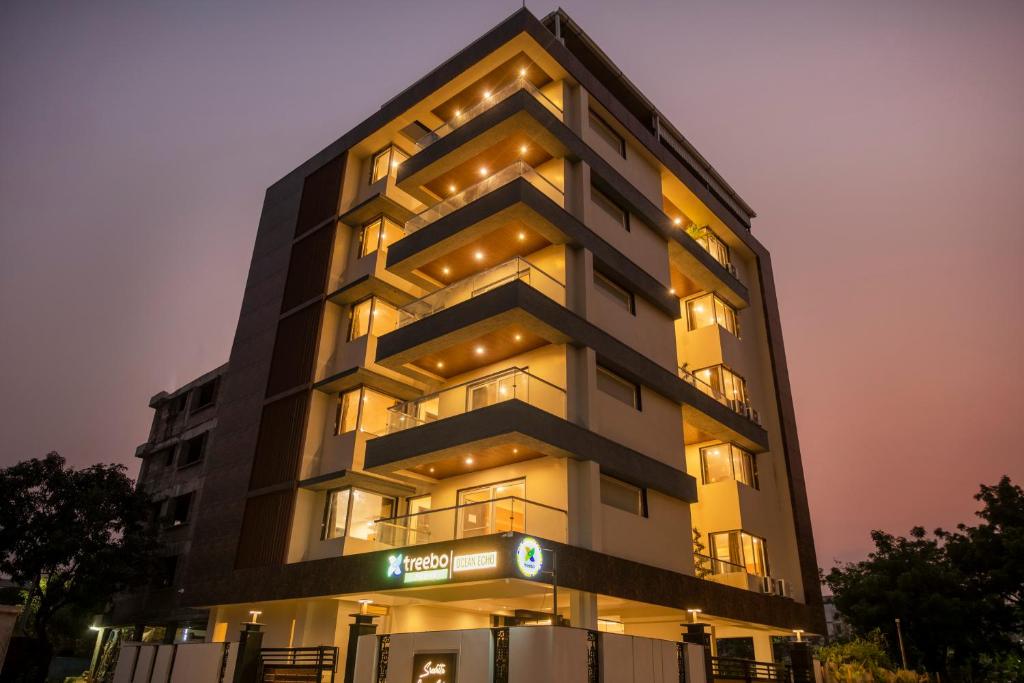 a tall building with lights on it at night at Treebo Premium Ocean Echo, Rushikonda in Rushikonda