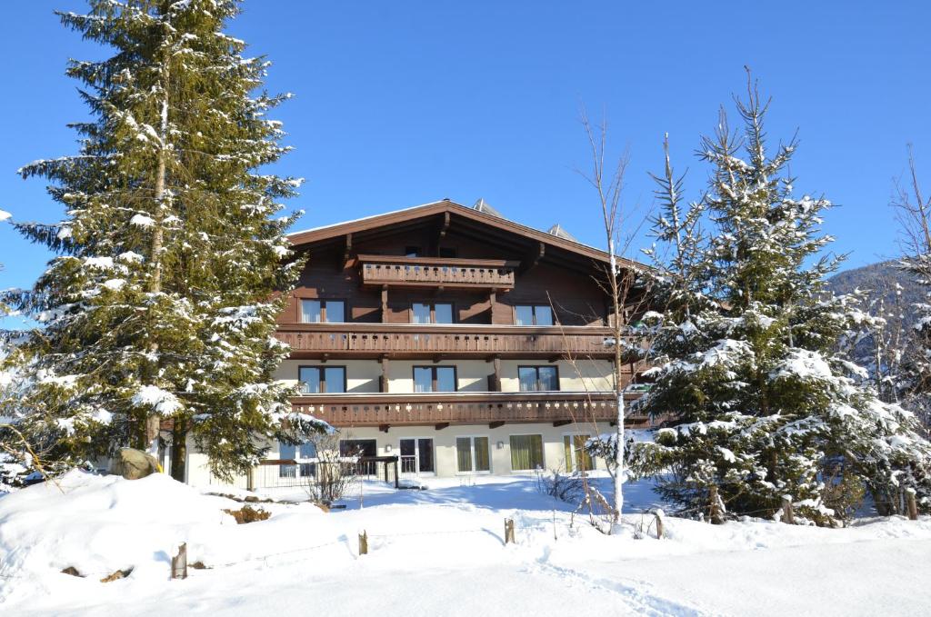 a large building in the snow with trees at Hotel Wieser in Mittersill