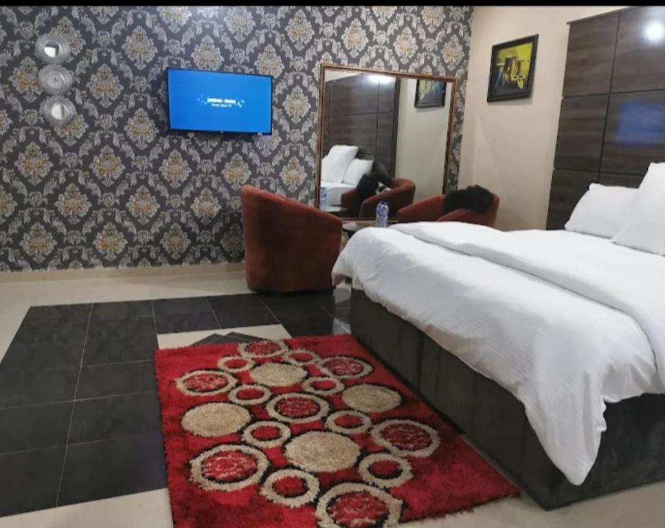 1 dormitorio con cama y alfombra roja en Keton Suites and Apartments, en Abuja