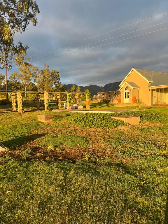 une cour avec une maison en arrière-plan dans l'établissement The Schoolhouse at Meulplaas, à Montagu