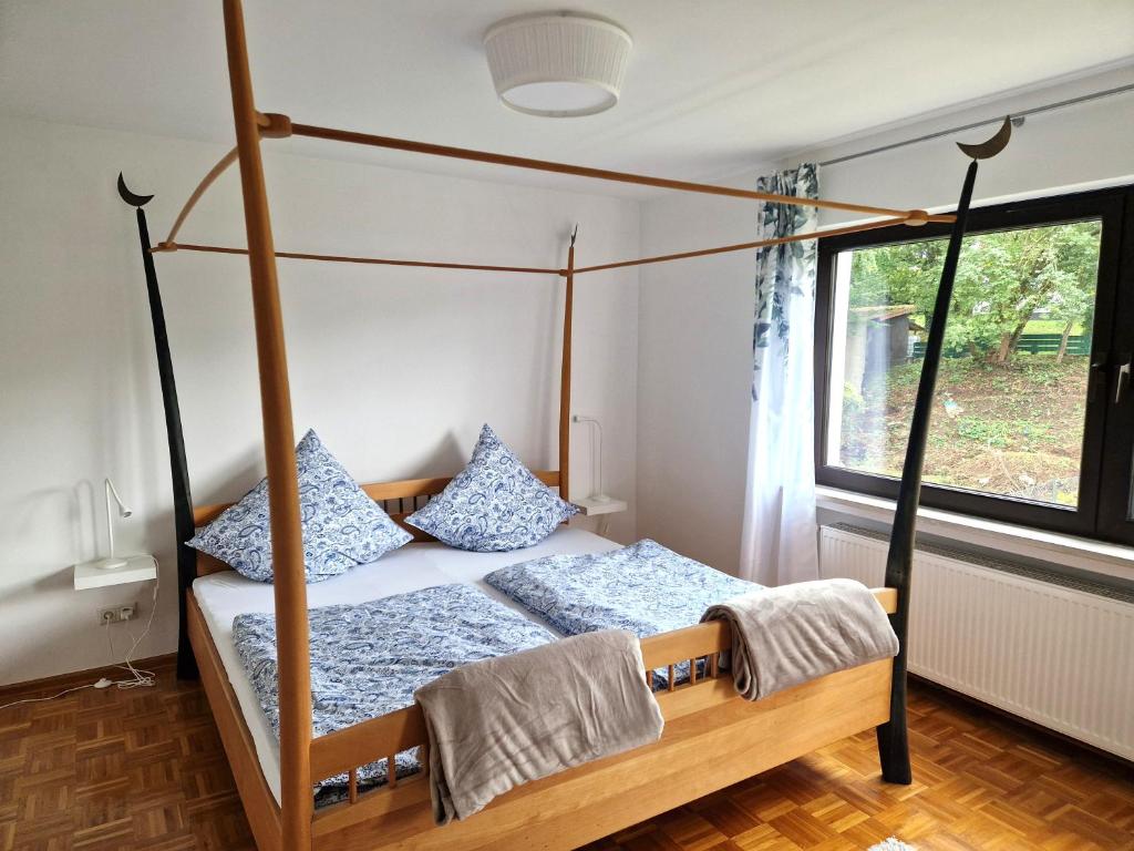a bedroom with a four poster bed and a window at Nanas-Auszeit in Rothenbuch