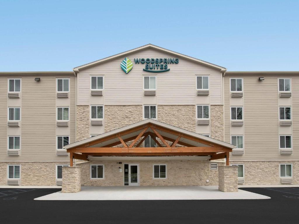a large building with a sign on top of it at WoodSpring Suites Orlando East UCF in Orlando