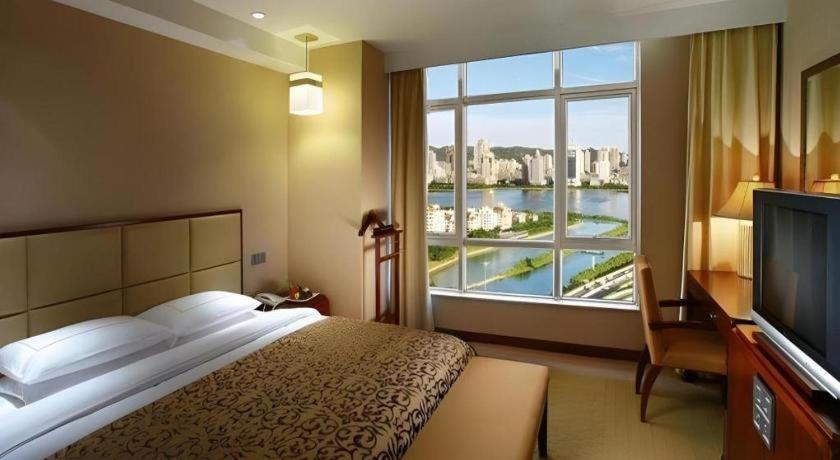 Postel nebo postele na pokoji v ubytování Xiamen Fortune Hotel