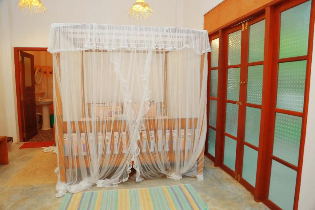 a white curtain in a room with windows at Secret Paradise One BedRoom Apartment in Unawatuna