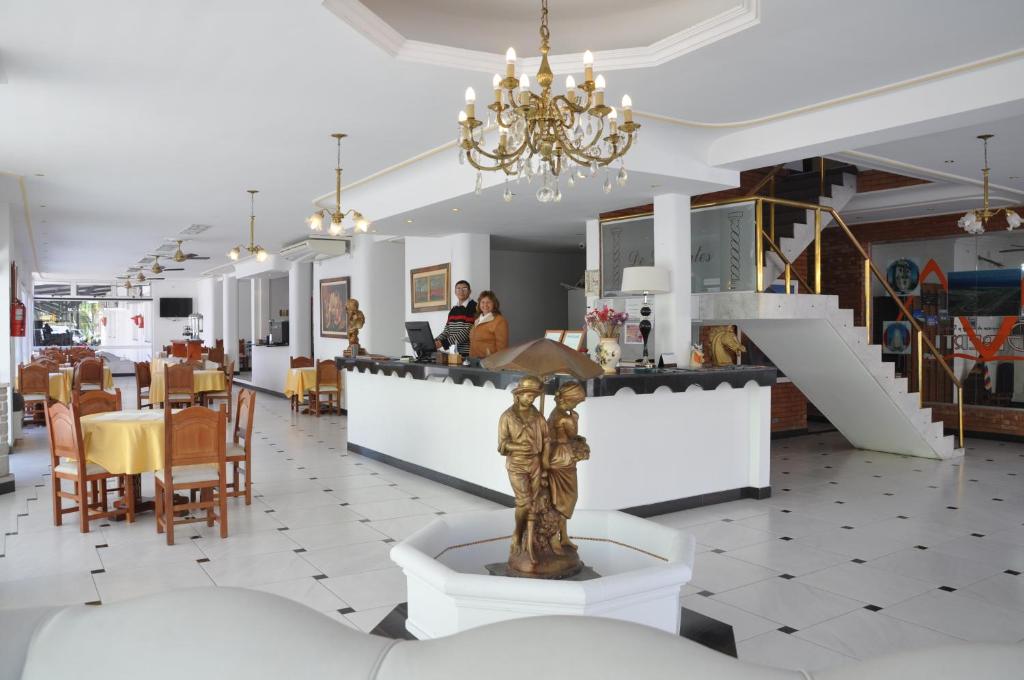 a restaurant with a statue in the middle of a room at Hotel De Las Artes in Termas de Río Hondo