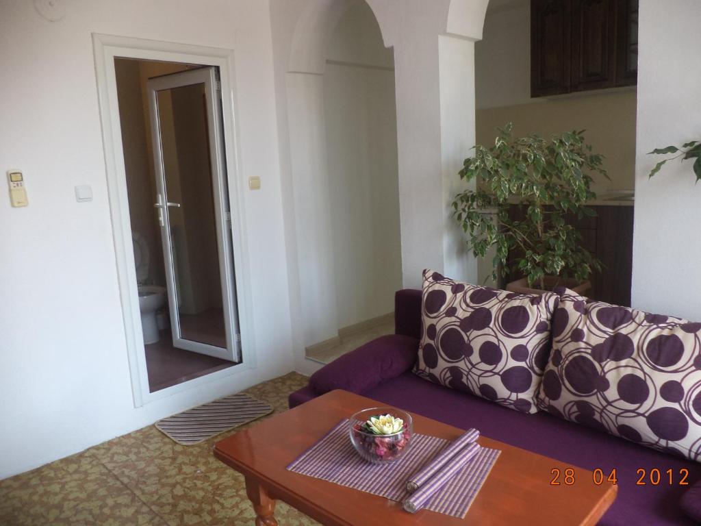 a living room with a purple couch and a table at Guest House Liliya in Sozopol