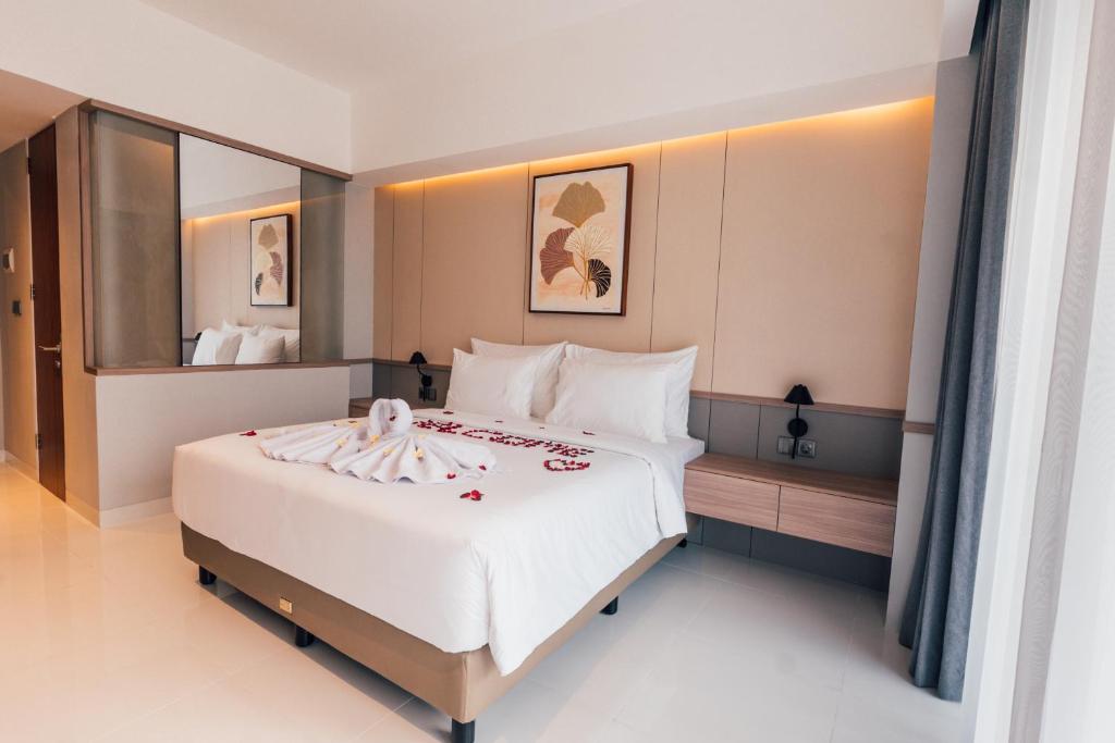 a bedroom with a large bed with white sheets at Royal Sweet By Sika in Canggu