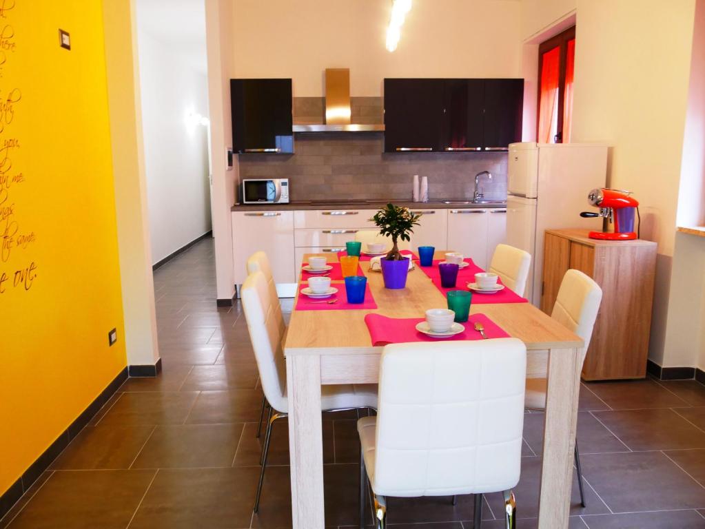 uma cozinha com uma mesa de madeira com cadeiras e uma sala de jantar em Casa Namasté em Lecce