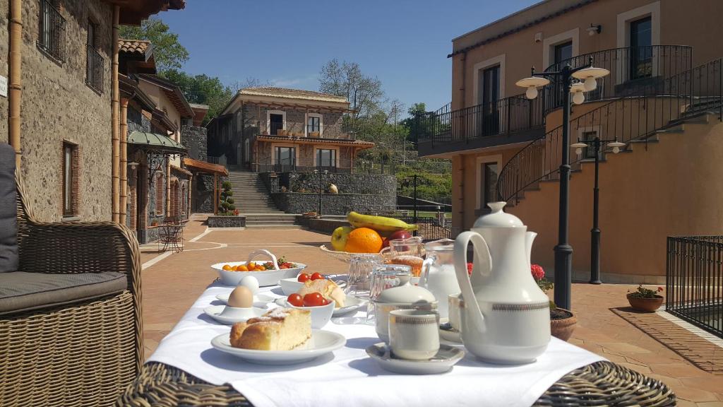 un tavolo con piatti di cibo sopra di Antico Borgo Petralia a Zafferana Etnea