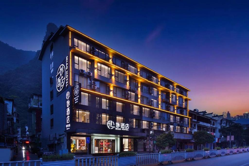 een groot gebouw met lichten aan de zijkant bij 妙酒店阳朔西街漓江店 in Yangshuo