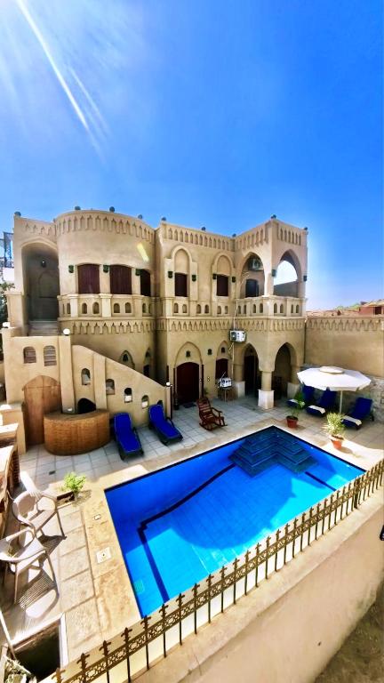 a large house with a swimming pool in front of it at Villa Nur in Luxor