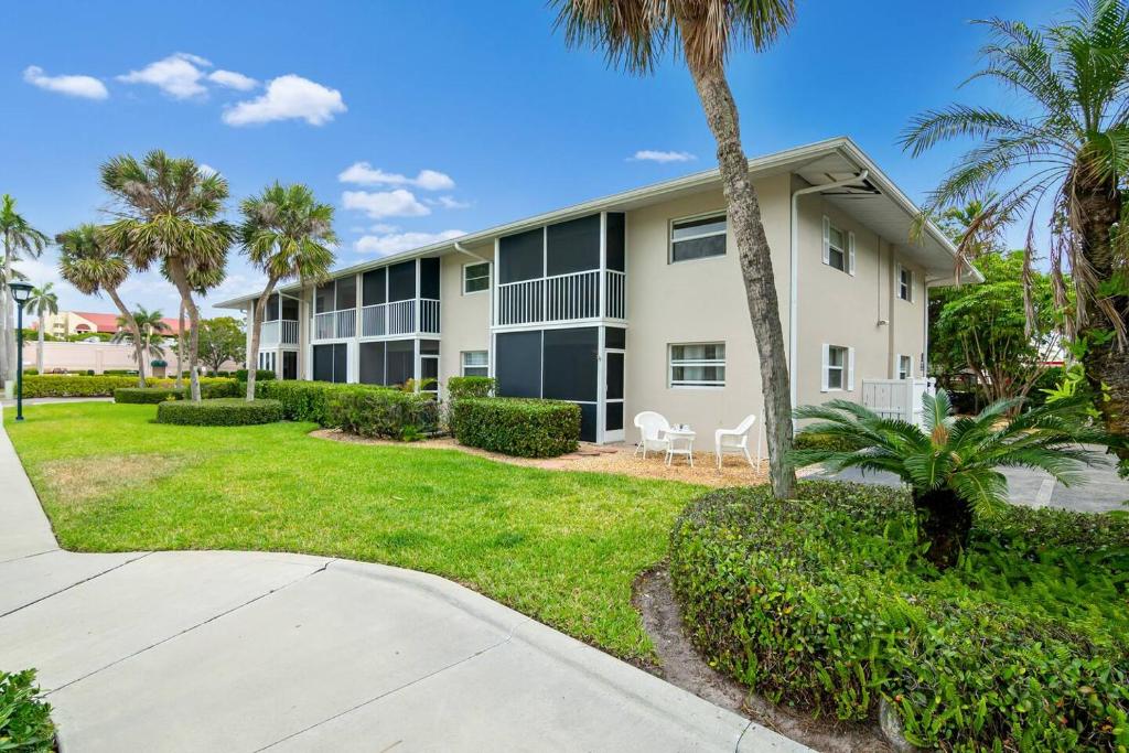 a apartment building with palm trees and a sidewalk at Olde Naples Paradise 803 in Naples
