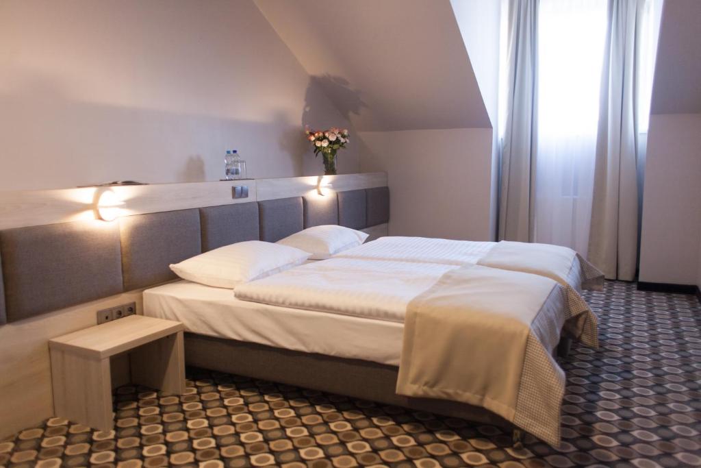 1 dormitorio con 1 cama grande con sábanas blancas en Noclegi Restauracja Piwnica Rycerska, en Kęty