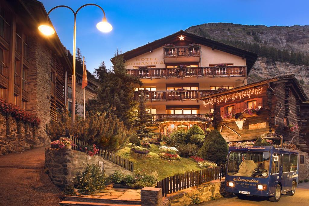 ein großes Haus mit Garten davor in der Unterkunft Hotel Romantica in Zermatt