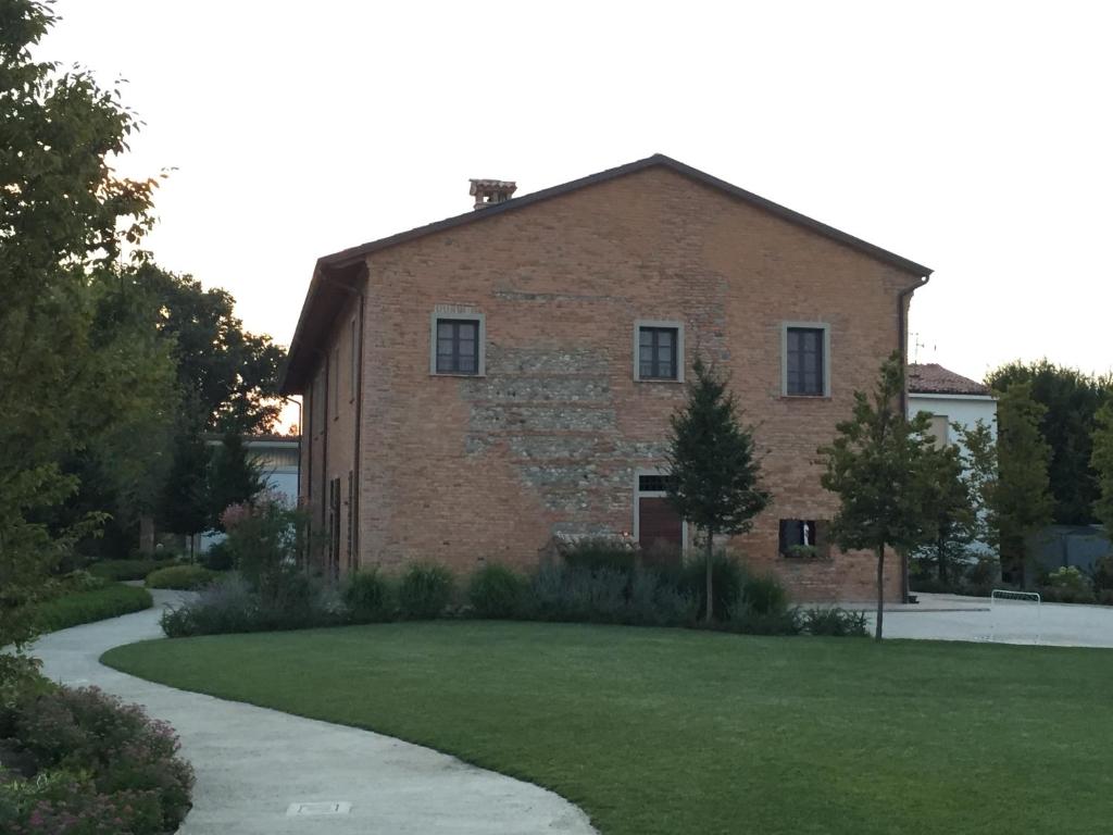 um grande edifício de tijolos com relva em Agriturismo Da Luca em Calendasco
