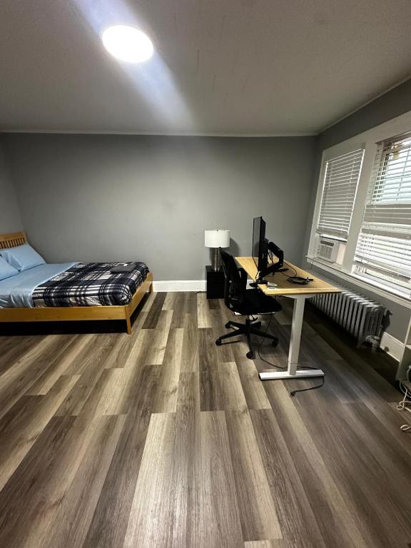 a bedroom with a bed and a desk with a computer at Room Near Downtown Hartford in Hartford
