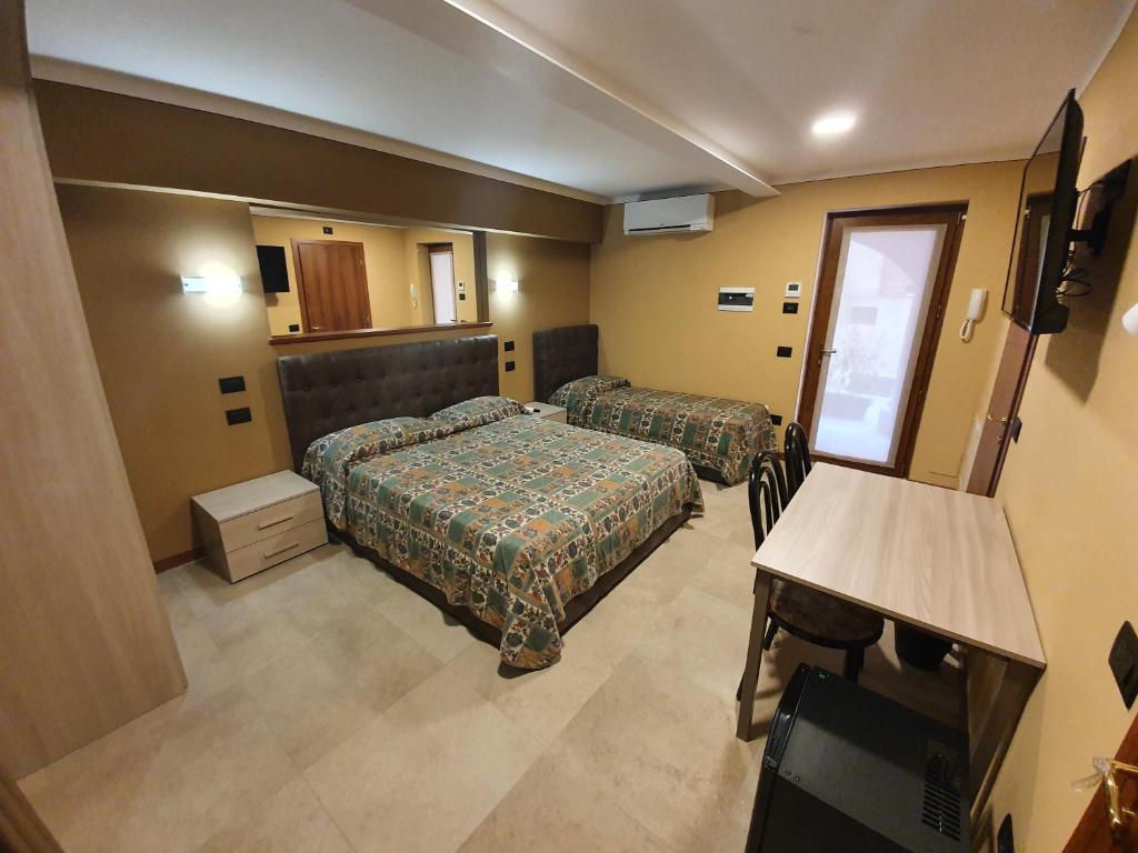 バヴェーノにあるazalea Rooms & apartments domo 3のベッド2台とテレビがあるホテルの部屋