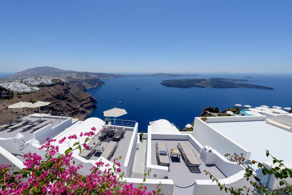 una vista del océano desde el lado de un edificio blanco en Krokos Villas, en Imerovigli