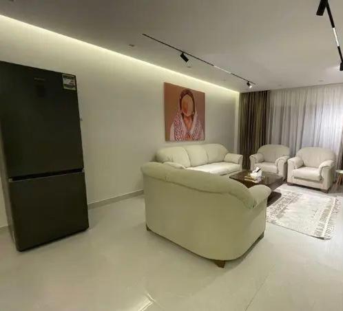 a living room with a white couch and chairs at saudia jabooo in Dammam