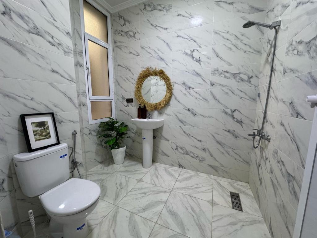 a white bathroom with a toilet and a sink at Charming apartment heart of Medina Tetouan 2BR in Tetouan