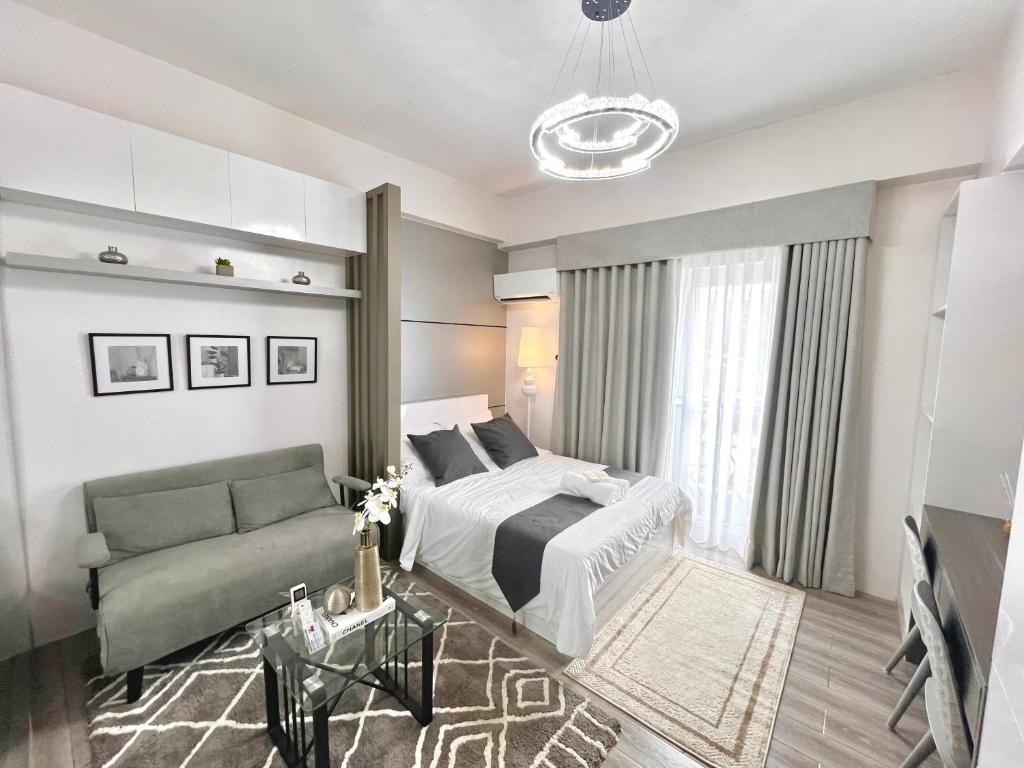 un dormitorio con una cama y un sofá en The Cavana Suites, en Pusok