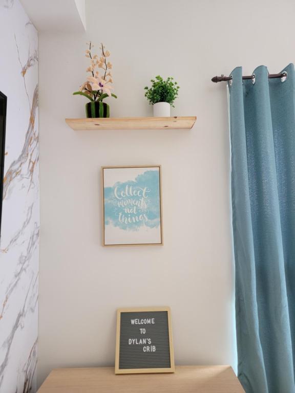 Un estante sobre una mesa con una cortina azul en Dylan's Crib, en Bacolod