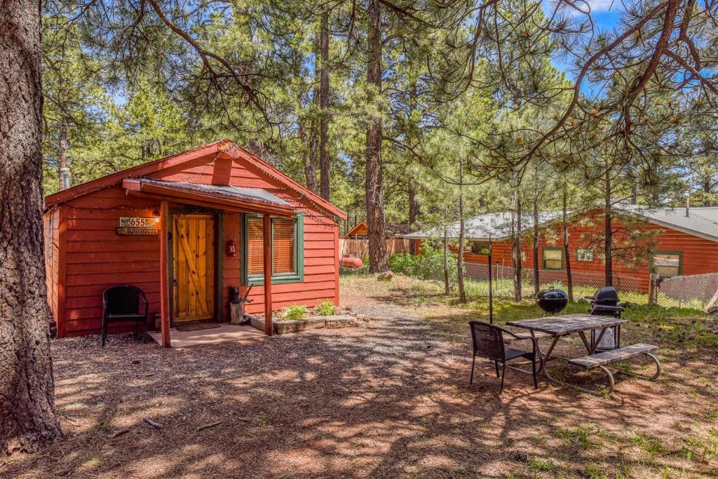 Cabaña roja pequeña con mesa y parrilla en Rustic Adventure w Historic Log Cabin Forest Views 20 minutes from Flagstaff Now with Wi-Fi, en Parks