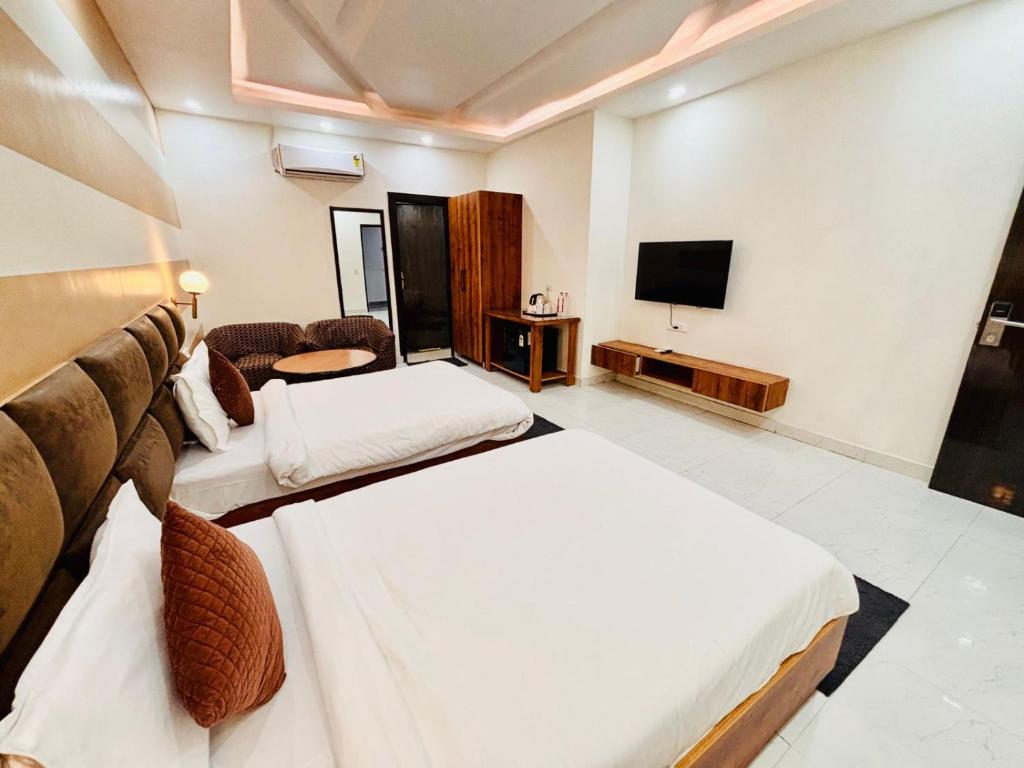 a hotel room with two beds and a television at Murthal Green Plaza Hotel in Sonīpat