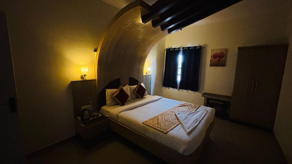 a bedroom with a bed in a room with an arch at VR Residency in Ooty
