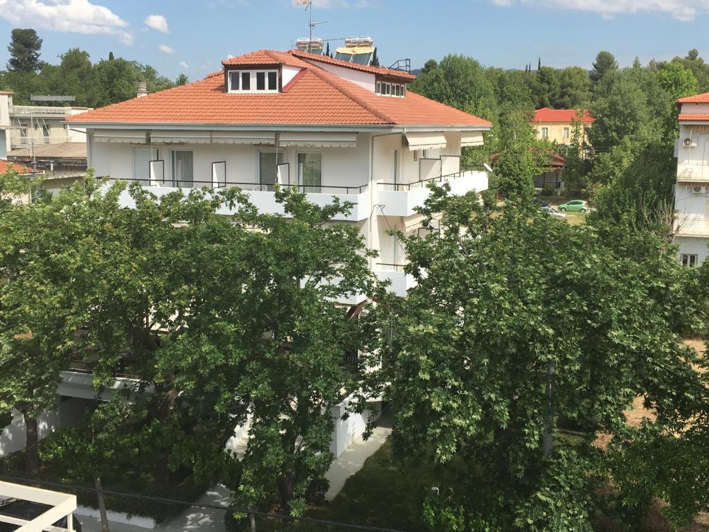 ルートラ・イパティスにあるHotel Esperiaの木の上にオレンジ色の屋根を持つ白い建物