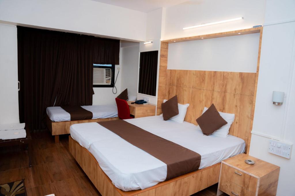a bedroom with two beds in a room at Hotel Woodland in Mumbai