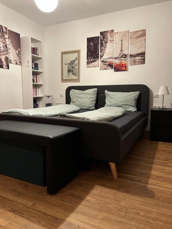 a bed in a room with a black bed frame at Charmantes Feriennest vor Seßlachs Stadtmauer im lebendigen Familienhaus in Seßlach