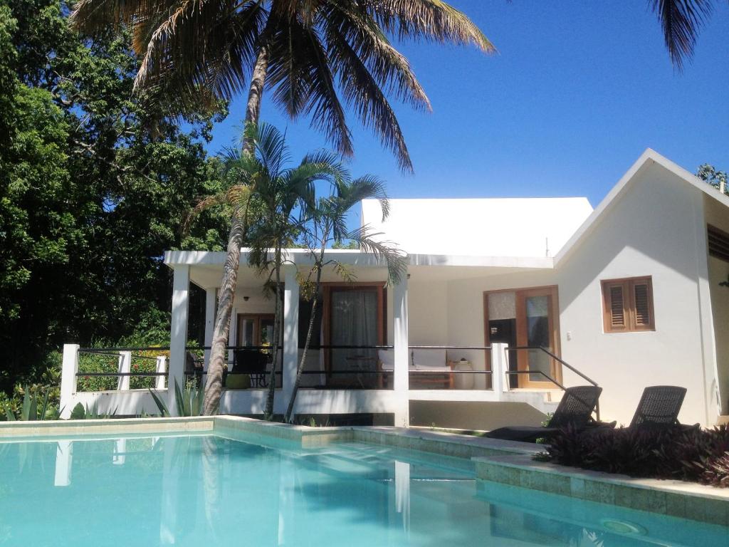 a villa with a swimming pool in front of a house at Casa 01 in Cabrera