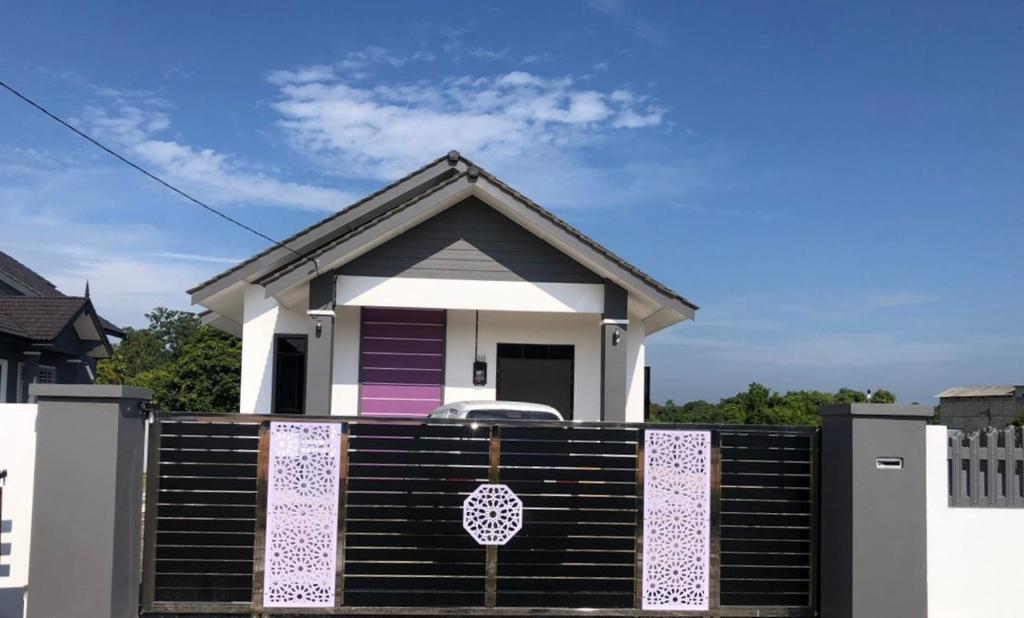 ein Haus mit einem Tor davor in der Unterkunft Casa Amethyst in Kuala Terengganu