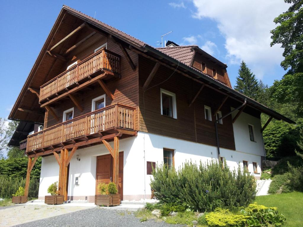 a house with wooden balconies on the side of it at Apartmány Base Camp in Železná Ruda