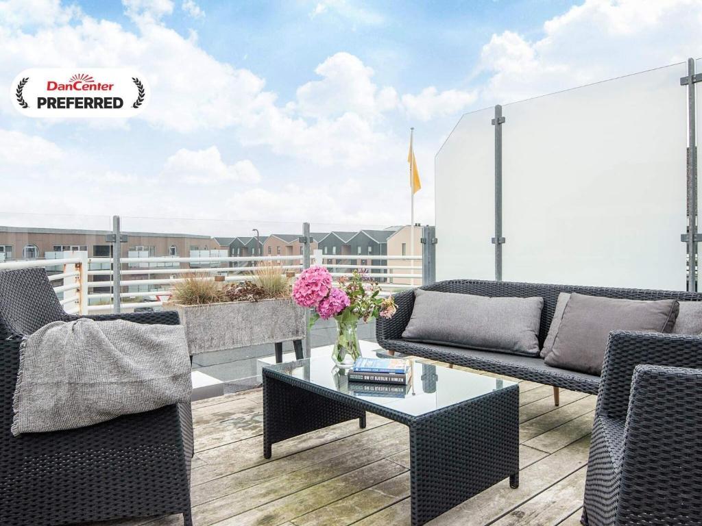 d'une terrasse avec des canapés et une table sur un balcon. dans l'établissement 8 person holiday home in Ringkøbing, à Ringkøbing
