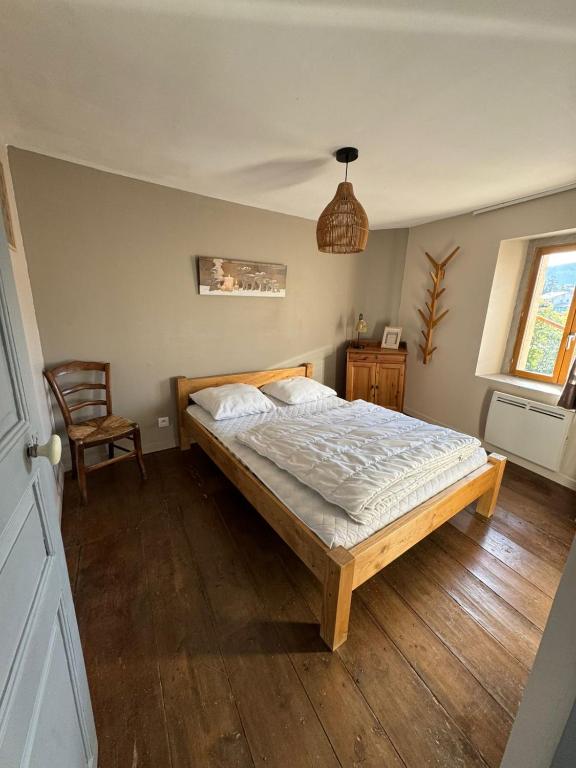 a bedroom with a bed and a chair at L'etoile Filante in Formiguères