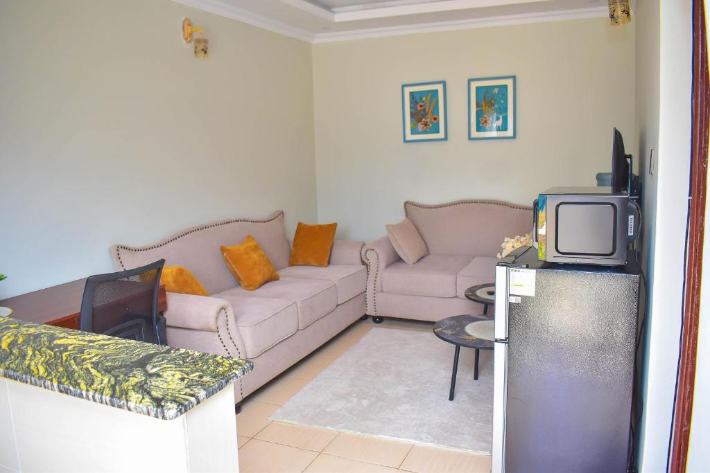 a living room with a couch and a tv at DeeHomes in Eldoret