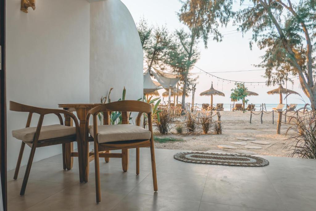 a table and chairs with a view of the beach at Villa Dot -Beach Front and private pool villa in Gili Air