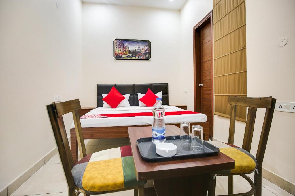 a room with a bed and a table and chairs at Hotel O Sky Line in Ludhiana