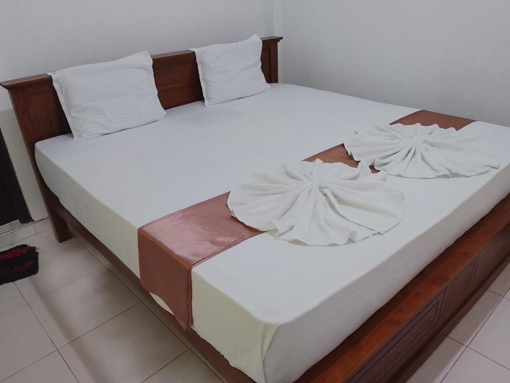 two beds in a bedroom with white sheets and pillows at Golden Heavens kengalla in Kandy