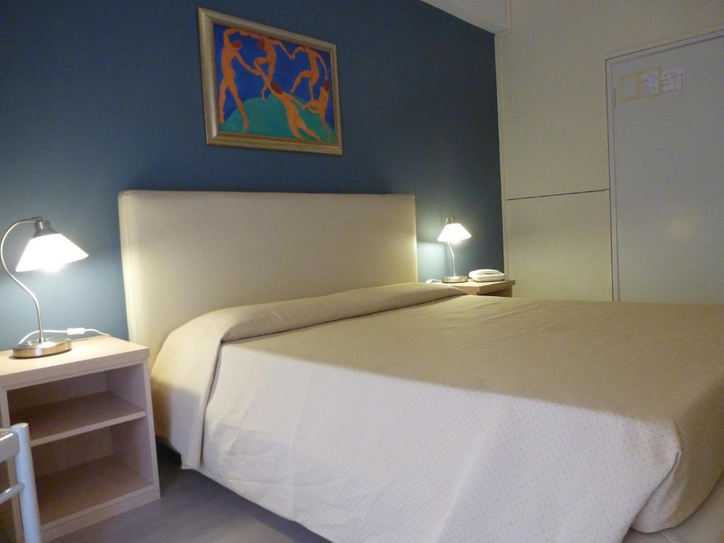 ストレーザにあるHotel Da Cesareのベッドルーム1室(ベッド1台付)が備わります。壁には絵画が飾られています。