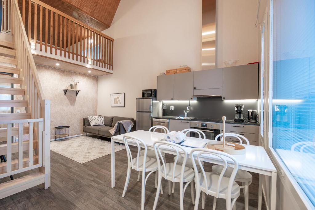 Una cocina y un comedor con mesa y sillas. en Aurinkorinne1 - Skistar spacious apartment with sauna, en Syöte