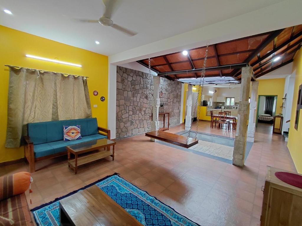 a living room with a blue couch and a table at SHI's Chettinad Courtyard Villa a 3BHK near Adiyogi in Alāndurai