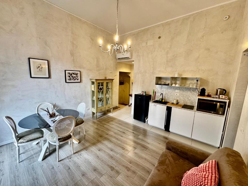 un soggiorno con tavolo e sedie e una cucina di Venustas Napoli a Napoli